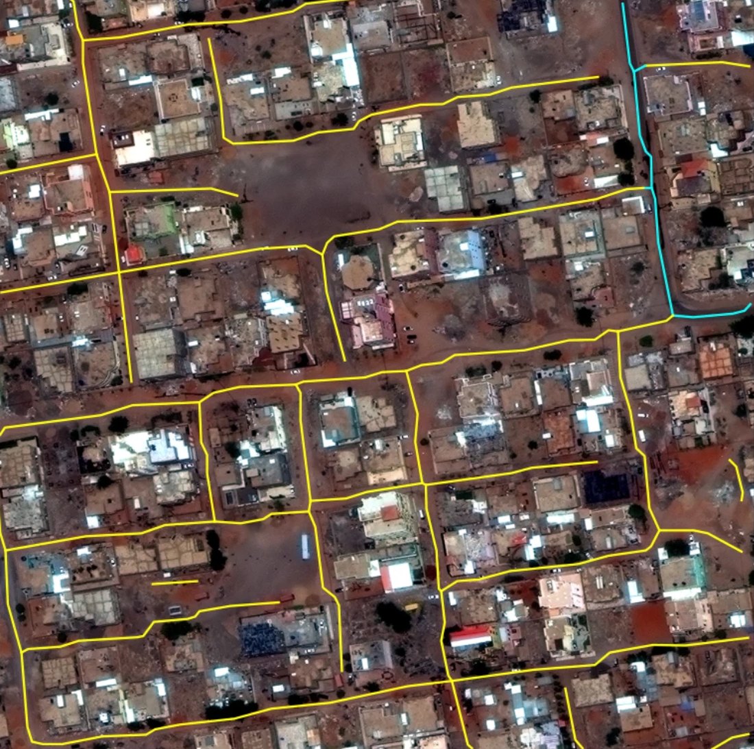 Satellite view of a Khartoum neighbourhood with the model's predicted roads drawn over it as coloured lines